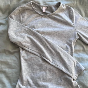 Grå långärmad tröja från Nelly - Säljer en stilren grå långärmad tröja från Nelly. Perfekt för lager-på-lager eller som den är. Tröjan har en rund halsringning och är gjord i ett mjukt material. ALDRIG ANVÄNT❤️ skicka för fler bilder💖