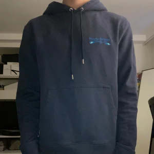 Mörkblå hoodie från Maison Kitsuné - Säljer en stilren mörkblå hoodie från Maison Kitsuné med design på bröstet. Storlek xs killen på bilden är 175 och skulle säga att den passar mellan 167-180. Nypris ca 2200. Väldigt bra skick och inga defekter. Hör av dig vid frågor.
