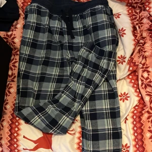 Rutig byxa från Kappahl - Säljer ett par bekväma rutiga byxor från Kappahl. Byxorna har en elastisk midja med snörning och är perfekta för en avslappnad stil. De är i en klassisk svart och grå färgkombination.