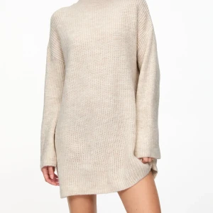 Beige stickad tröja - Säljer en mysig beige stickad tröja med lång ärm och hög hals. Perfekt för kyliga dagar och ger en avslappnad stil. Passar bra till både jeans och leggings. 