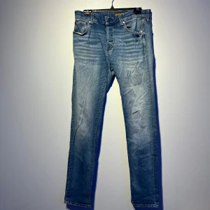 Blå jeans från Jack & Jones - Snygga blå jeans från Jack & Jones med en klassisk femficksdesign. De har en normal passform och är tillverkade i slitstarkt denim. Perfekta för en avslappnad stil.