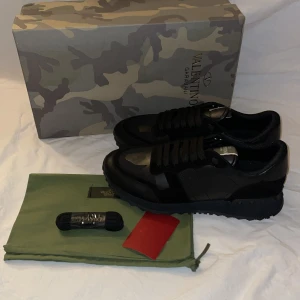 Valentino Rockrunners - Snygga Valentino Garavani sneakers i svart med kamouflagemönster. Skorna har en robust sula och klassisk snörning. Perfekta för en stilren look.