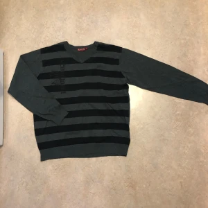 Grå och svart randig tröja från Redwood - Säljer grå och svart randig tröja från Redwood med riktigt schysst tryck vid bröstet, knappast använd och i perfekt skick står storlek L men sitter mer som M 