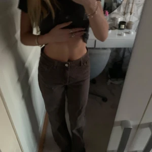 Monki bruna baggy Jeans - Snygga bruna byxor med rak baggy passform från Monki. De har en hög midja och är perfekta för en avslappnad look. Byxorna har knappar och dragkedja framtill. Är i nyskick😍