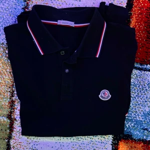 Pikétröja Moncler - Priset kan diskuteras vid snabb affär! (Nypris cirka 3500)Snygg svart pikétröja från Moncler med korta ärmar och klassisk krage. Storlek S men skulle säga att det passar någon som har M i vissa kläder också. Hör av er vid minsta fundering. Mvh: XpressResellSweden