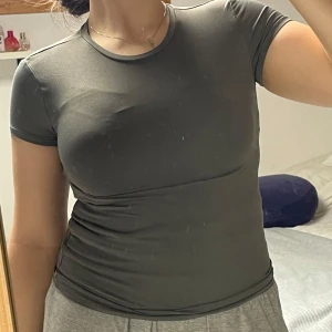 Grå figurnära t-shirt - Säljer en stilren grå t-shirt med korta ärmar. Perfekt för en avslappnad look.