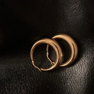 Guldiga hoops  - Snygga och eleganta guldiga creoler i en klassisk rund design. Perfekta för att ge en stilren touch till din look. Lätta att matcha med andra smycken.
