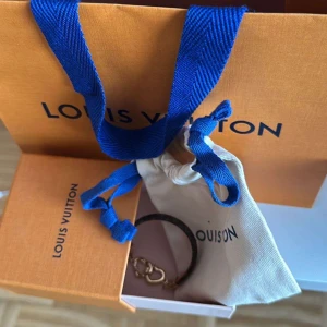 Louis Vuitton Say Yes Bracelet - Elegant armband från Louis Vuitton med ett klassiskt monogrammönster. Armbandet har en vacker guldfärgad detalj i form av två sammanlänkade hjärtan. Perfekt accessoar för att lyfta vilken outfit som helst. Orginal förpackning, påse och kvitto medföljer. Aldrig använd! Nypris: 3 850kr
