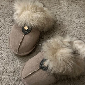 Beige tofflor  - Mysiga beige tofflor med fluffig pälsdetalj på ovansidan. Perfekta för att hålla fötterna varma under kyliga dagar. Från canada snow i stolek 39❤️