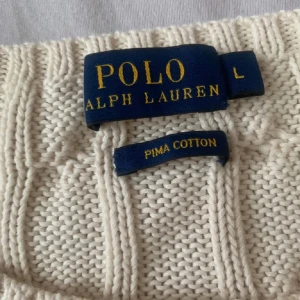 Polo Ralph Lauren tröja - Säljer en stilren vit stickad tröja från Polo Ralph Lauren!!!