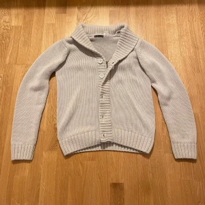 Stickad Cardigan - En unik stickad cardigan med både zip och knappar, sällsynt modell. Cardiganen är i storlek M. Hör av vid funderingar! PRISET GÅR ATT DISKUTERA!