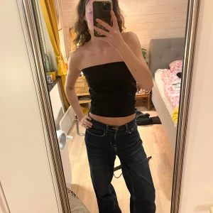 Svart tubetopp - Svart tubetop med dragkedja! Tror att denna egentligen ska vara en kjol men jag har alltid använt den som en snygg top istället med dragkedjan fram eller bak:)