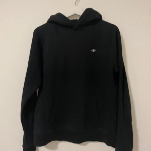 Svart hoodie från GANT - Säljer en stilren svart hoodie från GANT. Storlek S jättebra skick med inga defekter. Pris kan 100% diskuteras👍🙏.