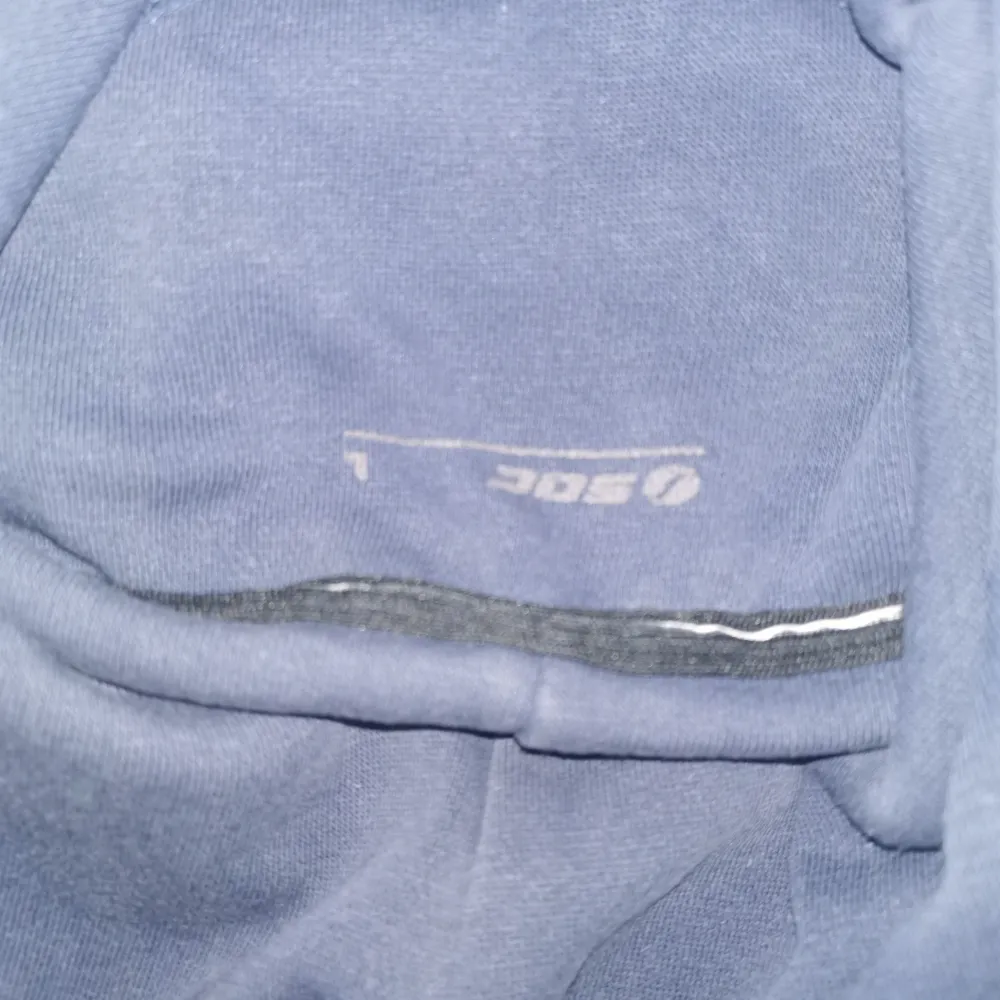Säljer en mörkblå hoodie från SOC med texten 'WORK CLOTHING' och 'ESTABLISHED IN 1989' tryckt på framsidan. Tröjan har en klassisk design med dragsko i huvan och långa ärmar. Perfekt för en avslappnad stil.. Neuletakit & Villapaidat.