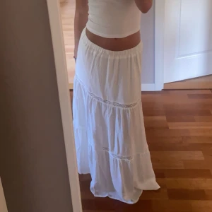 Vit långkjol med spetsdetaljer - Säljer en vacker vit långkjol med spetsdetaljer. Passar Xxs/xs men även S då jag fof kan ha den nu och bär S💕 använd fåtal gånger vid speciella tillfällen, skriv för fler frågor eller bilder!