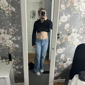 Svart croppad blus - Snygg svart croppad blus med långa ärmar och en stilren design. Perfekt för en trendig look.