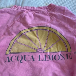 Rosa tröja från Acqua Limone - Säljer en rosa tröja från Acqua Limone med deras klassiska logga på bröstet och en stor citrontryck på ryggen. Tröjan har långa ärmar och ribbade muddar vid ärmslut och nederkant. ❤️