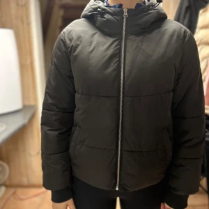 Svart pufferjacka med huva - Säljer en stilren svart pufferjacka med dragkedja och huva. Jackan har långa ärmar och är perfekt för kyligare dagar. Den är både bekväm och trendig. Jackan är från Nelly✨✨