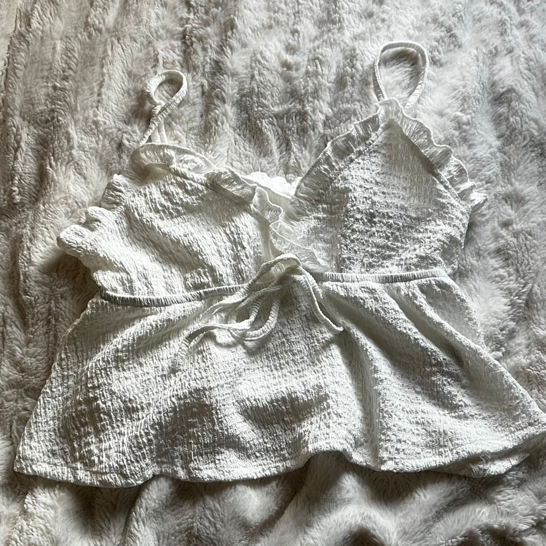 Vit ärmlös topp med volangdetaljer