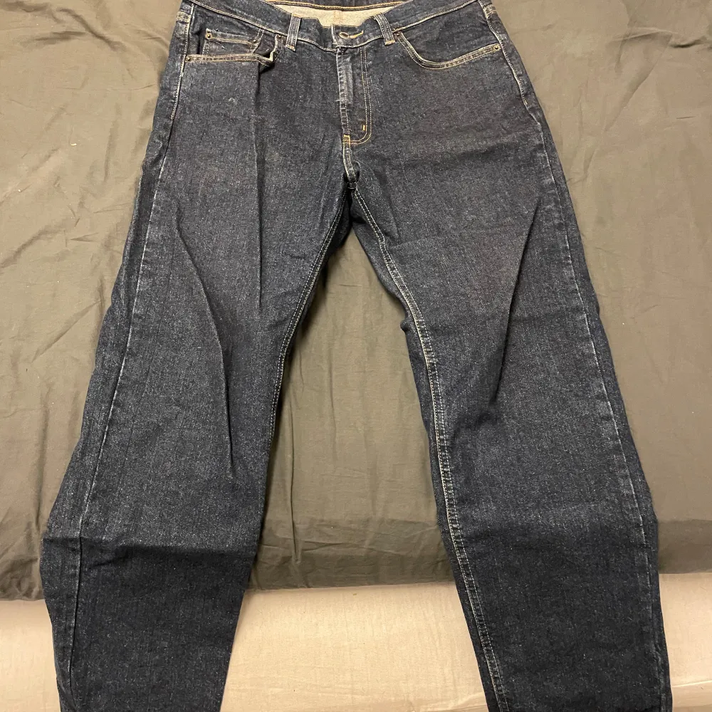Snygga mörkblå jeansbyxor med klassisk femficksdesign och dragkedja. Perfekta för en avslappnad stil. Passar bra till både sneakers och kängor.. Farkut & Housut.