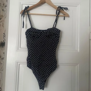Prickig body - Så snygg prickig body från zara som tyvärr inte passar mig. Knyts i rosetter vid banden. Står S men skulle säga att den är liten i storlek. 