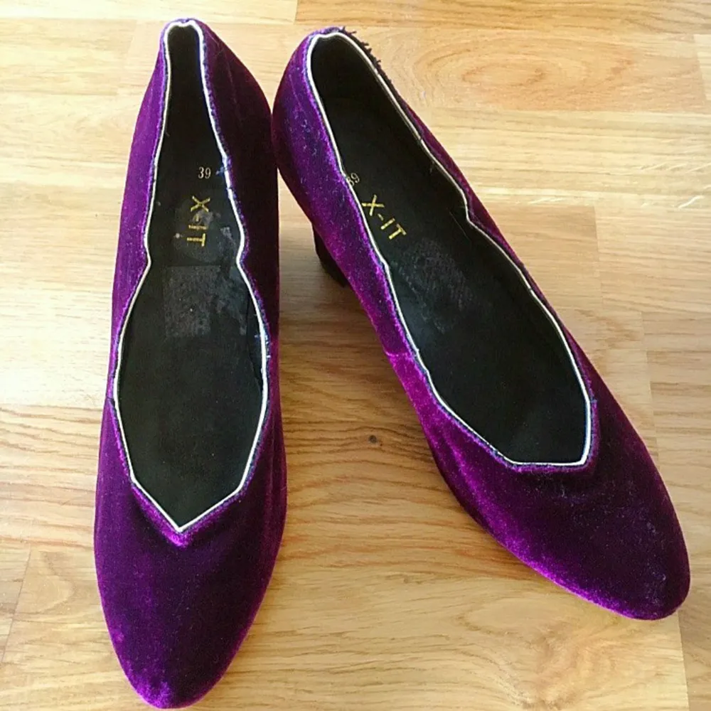 Säljer ett par eleganta lila pumps i sammet från XIT. Skorna har en spetsig tå och en bekväm klack som ger en stilren look. Perfekta för festliga tillfällen eller när du vill känna dig extra glamorös. De är i storlek 39 och i bra skick.. Skor.