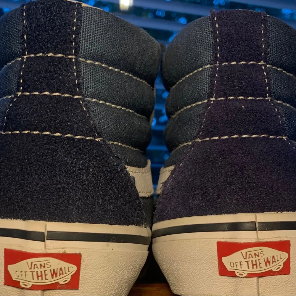 Säljer ett par snygga Vans Pro Classics Sk8-High sneakers i mörkblått och vitt. Skorna har en klassisk design med den ikoniska vågiga sidostripen och 'Off the Wall'-loggan på hälen. De är gjorda i slitstarkt material och har en bekväm passform med snörning. Perfekta för både vardag och skate! Skorna är i nyskick.. Skor.