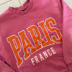 Tjocktröja  - rosa tjocktröja som är mjuk inuti. Det står Paris på tröjan.