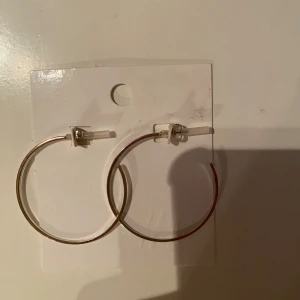 Stora silverfärgade hoop-örhängen - Säljer ett par stora och stilrena hoop-örhängen i silverfärg. Perfekta för att ge en enkel men elegant touch till vilken outfit som helst. De är lätta och bekväma att bära hela dagen. Passar både till vardags och fest!