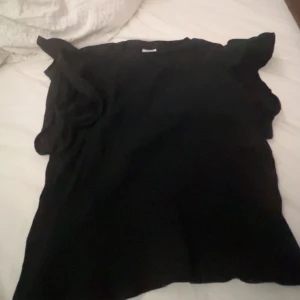 Svart topp från Zara - Säljer en svart topp från Zara i storlekar 140. Den är perfekt för både vardag och fest med sin stilrena design. Tröjan är egentligen långärmad men jag har klippt av ärmarna men det syns inte.