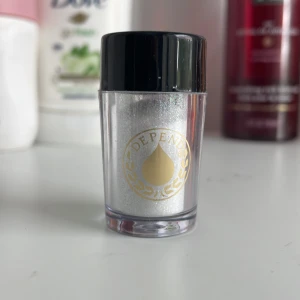 Silverglitter från Depend - Säljer ett superfint silverglitter från Depend. Perfekt för att lägga till lite extra bling till din makeup-look eller på naglarna! Kommer i en liten burk med svart lock, lätt att ta med sig. Innehåller 1,6 g glitter. Perfekt för fest eller när du bara vill glittra lite extra i vardagen!✨🪩💖