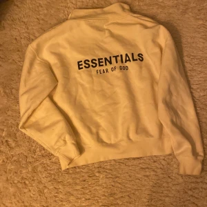 Beige Essentials tröja från Fear of God - Säljer en snygg beige tröja från Essentials by Fear of God. Den har en dragkedja framtill och är långärmad. Perfekt för en stilren och avslappnad look. Tröjan är i bra skick. endast använd 2 gånger och passar perfekt till höst och vinter.