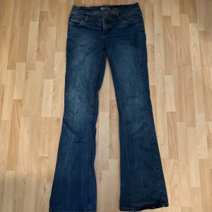 Blå jeans från EDC - Säljer ett par snygga blå jeans från EDC. De är i storlek 36/38 och har en klassisk femficksdesign med en broderad detalj på bakfickan. Jeansen är i bra skick och har en bekväm passform. Perfekta för vardagsbruk! Jeansen är lågmidjade!