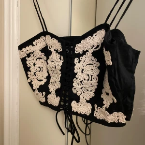 Topp H&M - Topp från H&M  Aldrig använd Snygg korsett liknande med knytning fram Storlek S