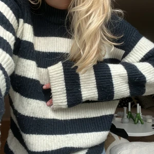 Snygg stickadtröja med trendig rak modell!! - Snygg stickad tröja!! Modellen är rak vilket är sjukt snyggt🩵 Den är randig i marinblått och vit!! Den är lite nopprig men inte mer än det som tillhör till en stickad tröja💙