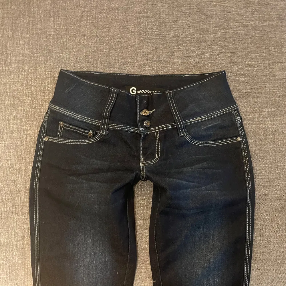 Säljer ett par svarta bootcut jeans. De är lågmidjade och har en tight passform upptill som sedan går ut i en bootcut-stil. Stretchigt och bekvämt material. Jeansen är i fint skick, dock saknas en knapp längst upp för dekoration men som inte kan användas. Finns 2 andra knappar så ser helt normalt ut!💞Jag är 165. Jeans & Byxor.