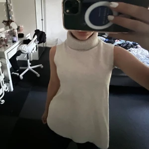 Beige ärmlös polotröja - Säljer en superfin beige ärmlös polotröja. Den är perfekt för lager-på-lager-stil under hösten. Tröjan är i ett mjukt och bekvämt material med en ribbad polokrage som ger en stilren look. Passar både till jeans och kjol❤️