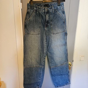 Blå jeansbyxor från ASOS Design - blå jeansbyxor från ASOS Design. loose fit med stora fickor både fram och bak. väldigt bra skick då de knappt används