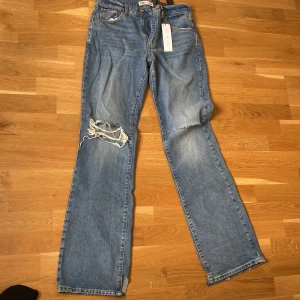 Midwaist med hål  - Blåa jeans med hål i knäna, nya oanvända 