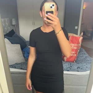 Svart klänning - Svart minidress från hm.  Går att ändra längden på den på sida med band! Ribbat material Stl S men stretchig!  99kr