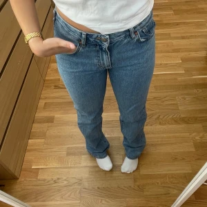 Blå jeans - Säljer ett par klassiska blå jeans i en snygg straight fit. De är högmidjade och har en enkel design med knappar och dragkedja framtill. Perfekta för vardagsbruk och kan matchas med nästan vad som helst!