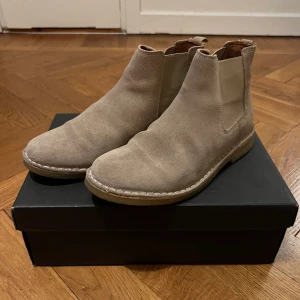Beiga chelsea boots i mocka - Beiga chelsea boots från Zign i mocka. En del fläckar från regn.