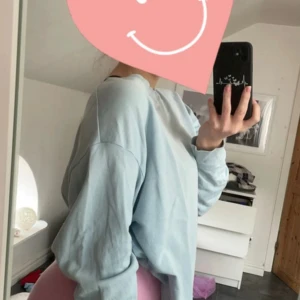 Ljusblå sweatshirt - Säljer en supermysig ljusblå sweatshirt. Den är perfekt för chilliga dagar och har en normal passform. Tröjan är långärmad och gjord i mjukt material som känns skönt mot huden. Perfekt för både vår och höst! Tröjan är lite urtvättad men annars inget större fel.