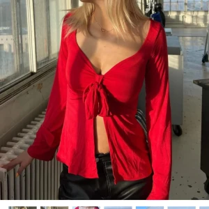 Långärmad topp med knyt - Säljer en snygg röd topp från Design by Si. Fint skick!! Storlek M/L. Nypris 393kr