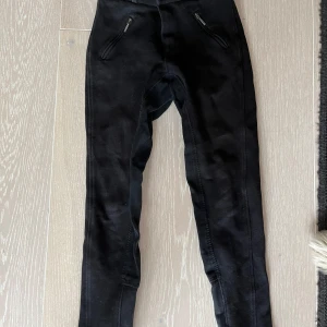Svarta ridbyxor från Horze - Säljer ett par svarta ridbyxor från Horze i storlek 160. De har dragkedjor vid fickorna och en knapp i midjan. 
