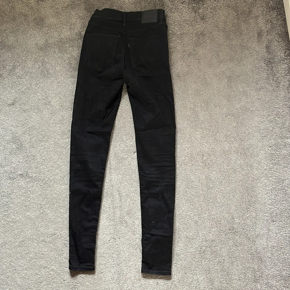 Säljer ett par svarta Levi's Mile High Super Skinny jeans i storlek 26. De är högmidjade och har en tight passform som passar dig som är ca 170 cm lång. Perfekta för både vardag och fest! 🖤. Jeans & Byxor.