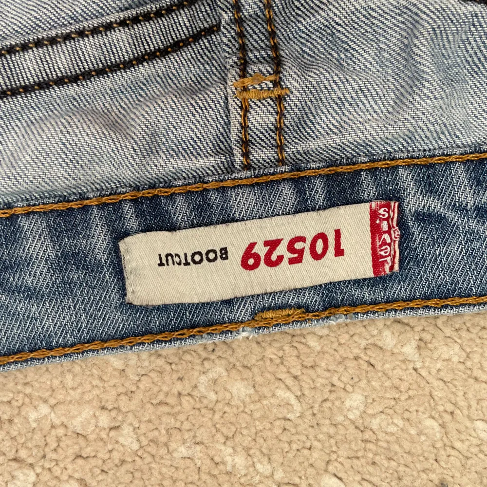 Säljer ett par Levis 512 bootcut jeans i en ljusblå tvätt. De har en klassisk femficksdesign och är lite slitna vid knäna för en cool, vintage look. Perfekta för en avslappnad stil!. Jeans & Byxor.