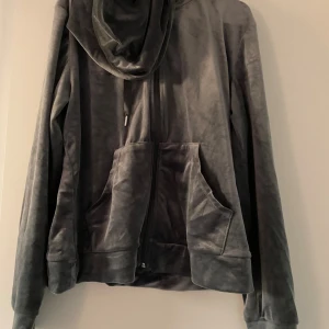 Grå hoodie från Juicy Couture - Säljer en supermjuk och skön grå hoodie från Gina tricot. Den har en dragkedja framtill och en stor luva. Perfekt för mysiga dagar eller som ett extra lager när det är lite kyligt. Den har också praktiska fickor framtill. Passar perfekt till både vardag och chill. Hör gärna av er vid frågor eller fler bilder💕