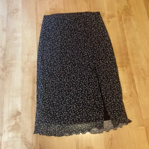 Kjol från H&M  - Midikjol med vita blommor från h&m. I nyskick, storlek M med en slits. Skriv gärna vid frågor 💕