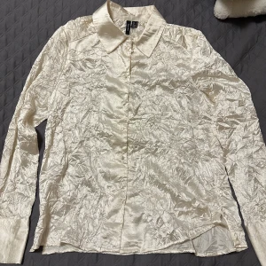 Skrynklig skjorta - Säljer denna åt min mamma. Cremefärgad skrynklig skjorta från Vero Moda. Storlek S, normal i storleken. Använd fåtal gånger, därmed bra kvalitet